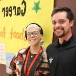 B.F. Day Counselors smile at camera while standing in front of yellow Career Week poster.